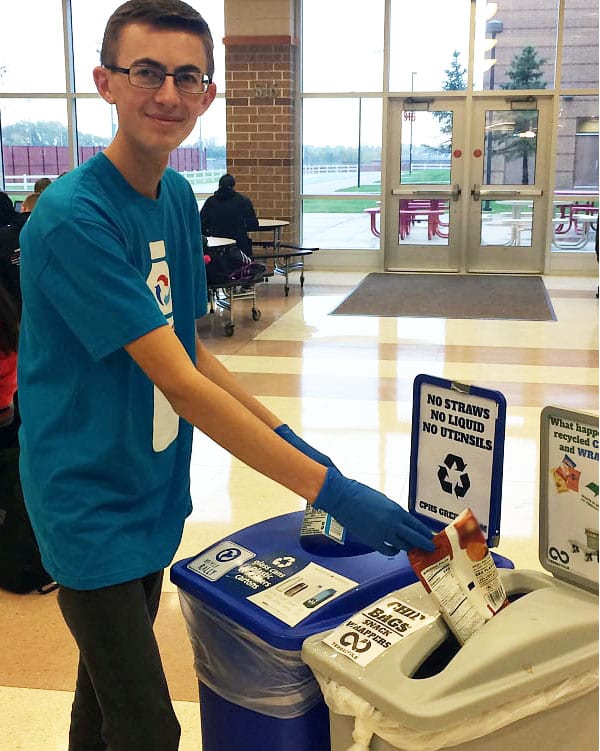 Student putting something into recycling can