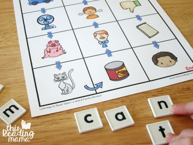 Child using letter tiles to spell out words on a pictorial worksheet (Phonics Activities)