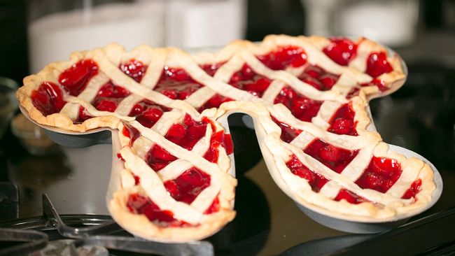 Pie pan shaped like the pi symbol containing a red pie with a lattice crust