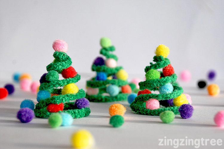 Holiday trees are fastened out of green pipe cleaners and rainbow pom poms.