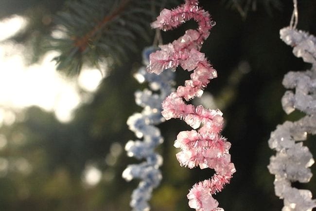 pink, silver, and white pipe cleaners are twisted and hanging from a tree.