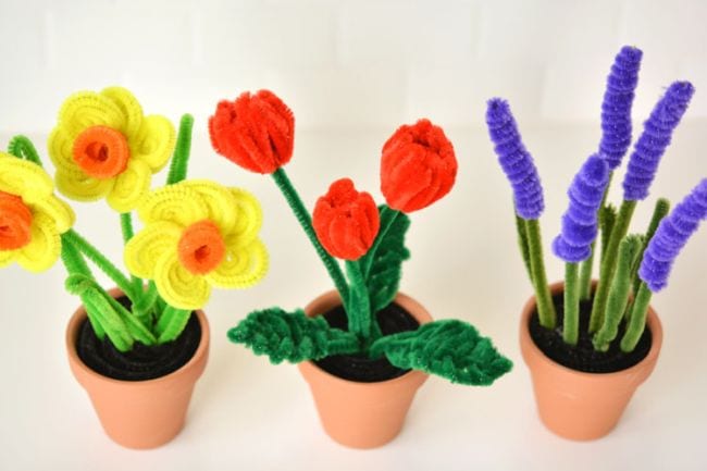 Pipe cleaners are twisted into flowers and placed into three different pots.