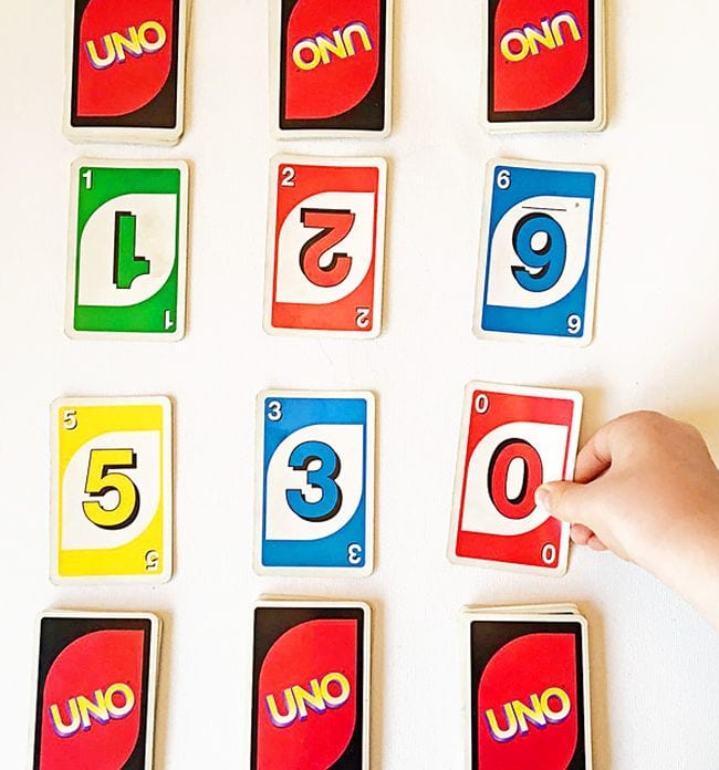 Student's hand laying out UNO cards in three rows