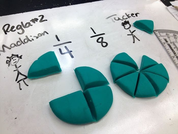 Whiteboard with fractions and play do representing fractions