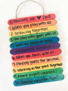 Several rainbow popsicle sticks are stacked together with sweet messages written on them in this example of Father's Day kids crafts.