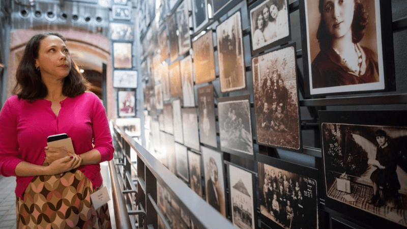 Photograph of a visitor looks at photos of daily life before the Holocaust in the Museum's main exhibition.