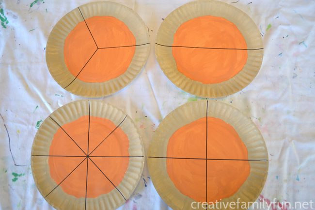 paper plates painted like pumpkins and divided into fractions
