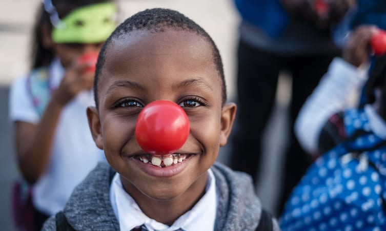 A young boy wearing a red nose on Red Nose Day.