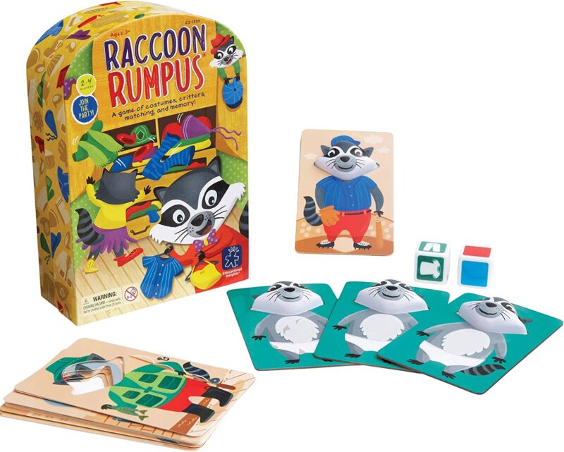 A box says raccoon Rumpus. There are several cards with rcacoons on them laid out and dice.. 