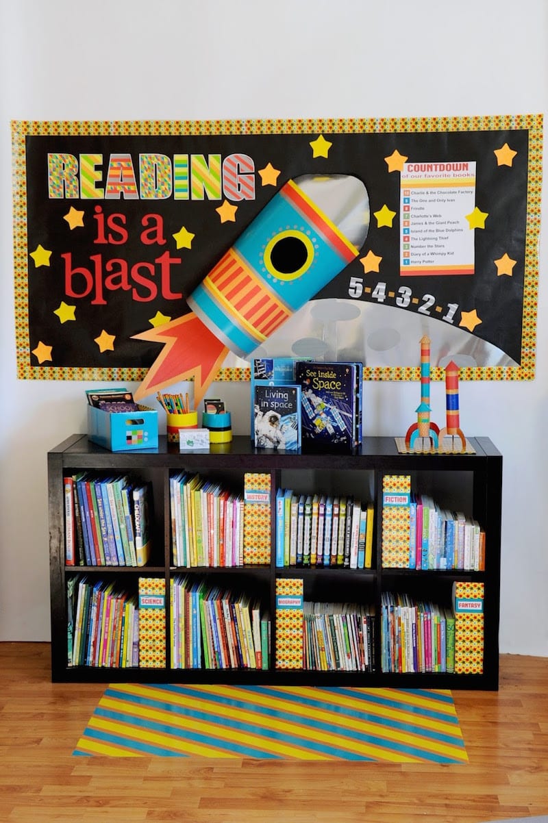Black classroom bookshelf with "reading is a blast" space wall display