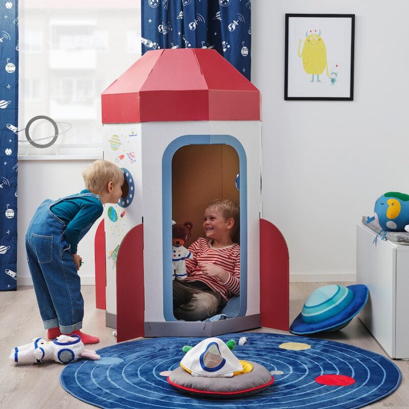 Two small children play inside a cardboard rockets hip tent in this example of  Ikea classroom