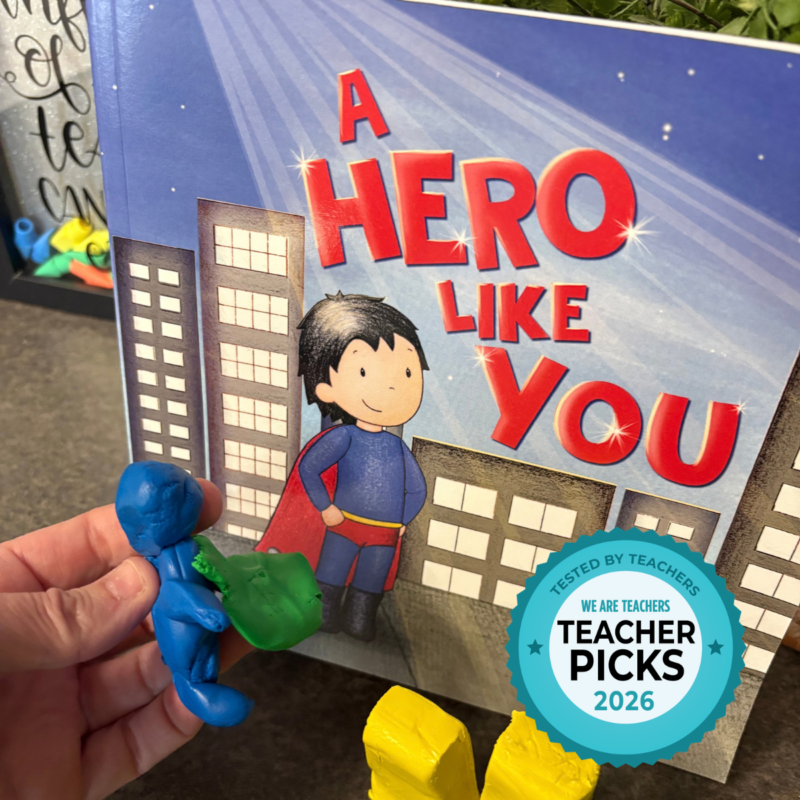 Student holding super hero book character made out of clay.