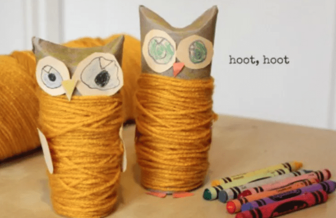 Yarn wrapped around a cut-out paper head of an owl.