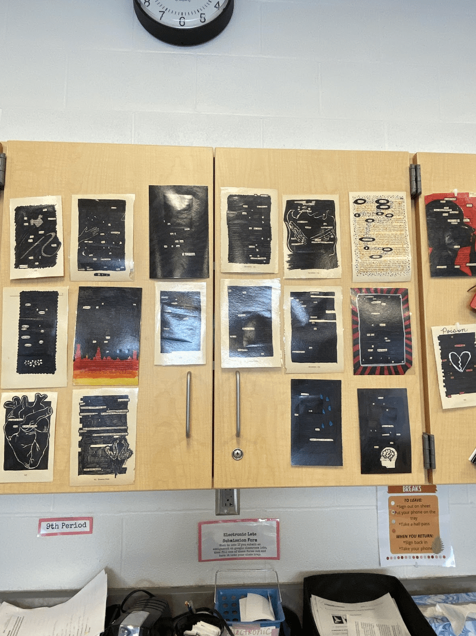 Blackout poetry pages hung on a cabinet