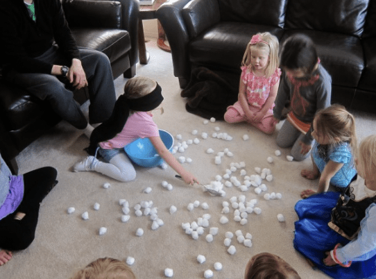 Kids picking up foam balls from the floor, as an example of minute to win it games for kids
