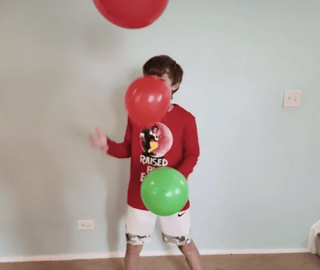 Kid bouncing balloons in the air