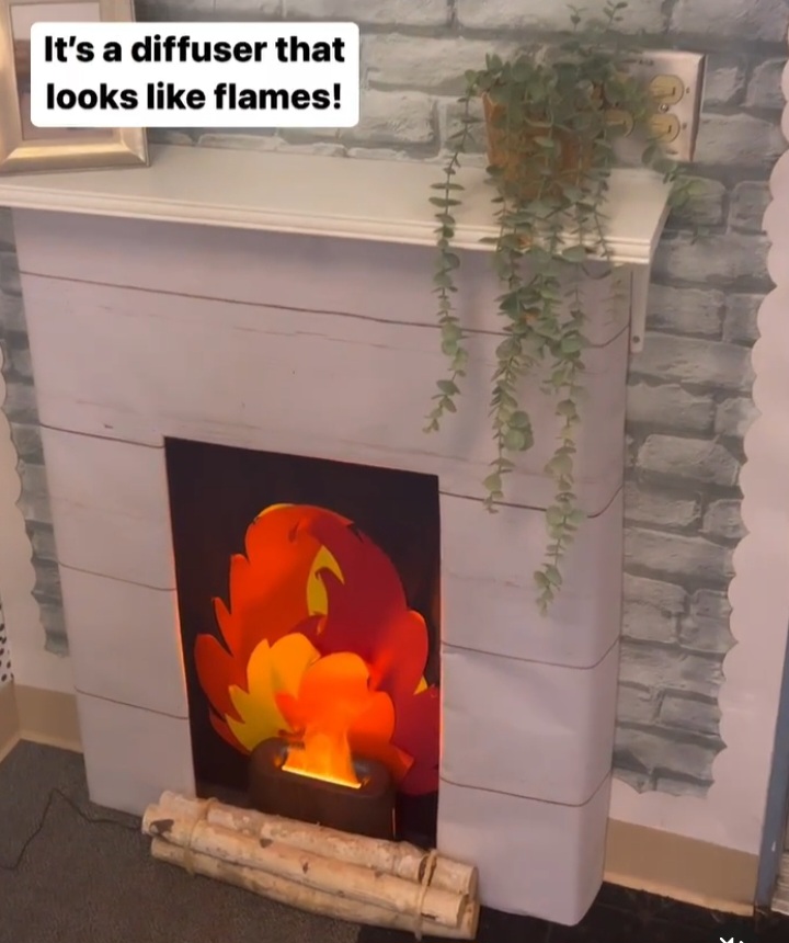 A cardboard fireplace has a diffuser that looks like flame in the middle.