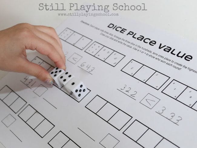 Second grade math student placing dice on a worksheet labeled Dice Place Value