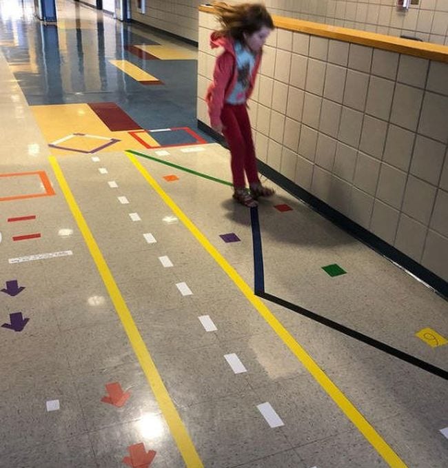 Tape lines on hallway floor marking running lanes, balance lines, and jumping spots
