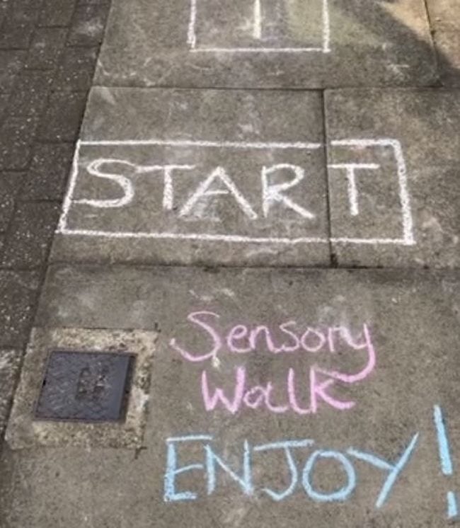 Sidewalk decorated with a sensory walk showing block saying start