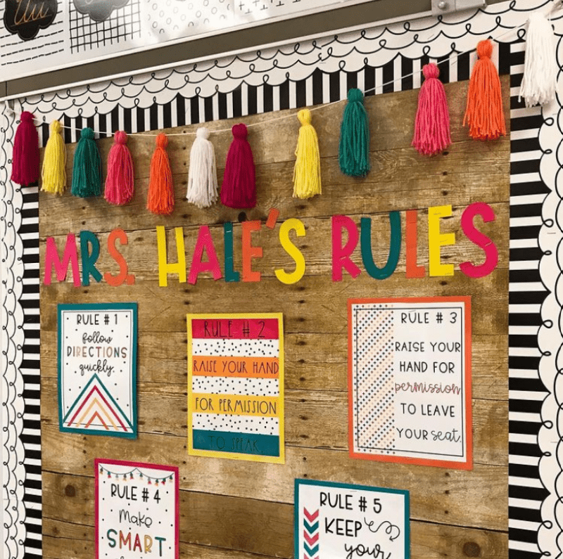 Bulletin board reading Mrs. Hale's Rules, with classroom rules listed on individual pages and brightly colored tassels across the top (Back-to-School Bulletin Boards)