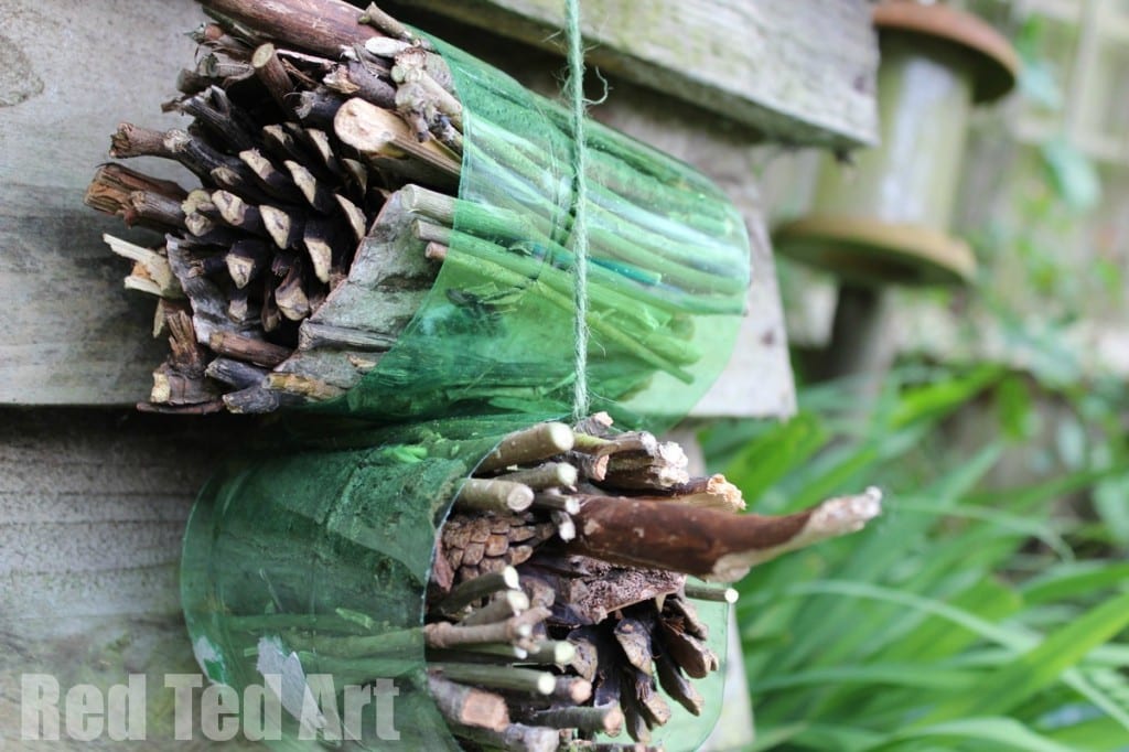 Green paper is wrapped around bundles of sticks and pinecones (earth day crafts)