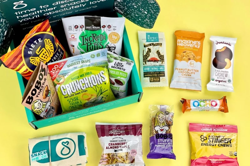 SnackSack Subscription Box on a yellow background with individually wrapped munchies and sweet, as an example of graduation gifts for students