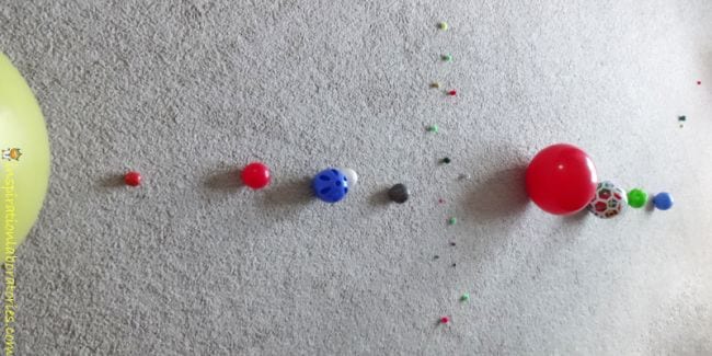 Space Activities for Kids- a collection of balls of different sizes laid out to represent the planets in order