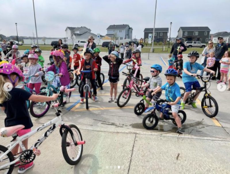 Kids on bikes in a school parking lot