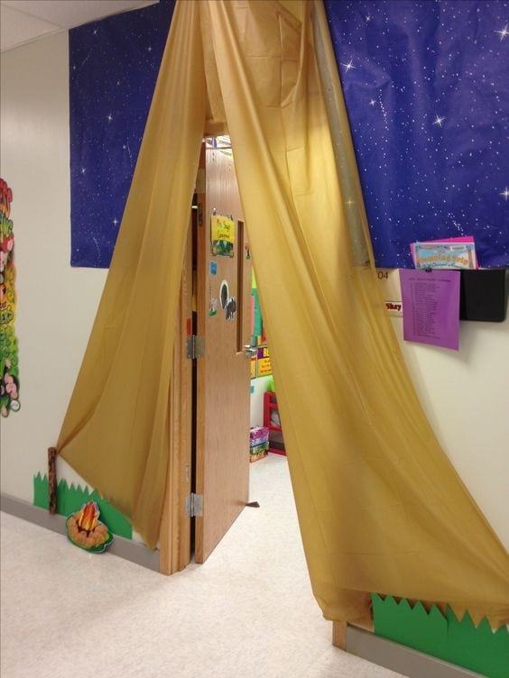 Light brown tablecloth hanging from a classroom door frame to resemble a tent. 