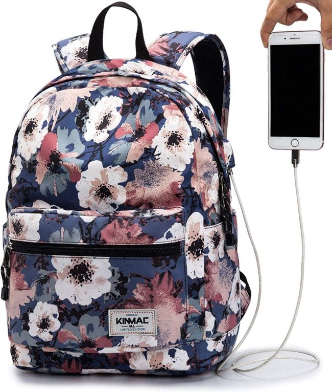 Floral patterned backpack with external charging port and hand holding smartphone
