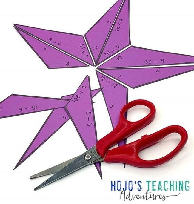 Paper star with division problems and answers, cut into pieces with pair of scissors