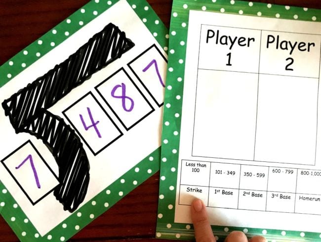 Card showing division problem 487 divided by 7 with game worksheet
