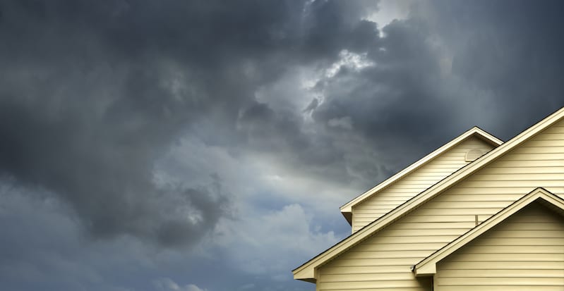 A picture of a house with a stormy sky above it.