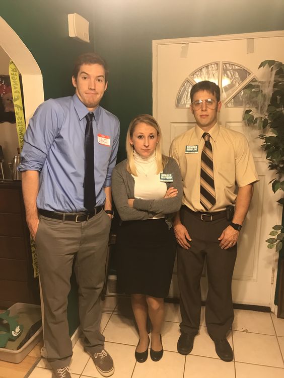 Three people are seen dressed in office attire as the characters from the sitcom.