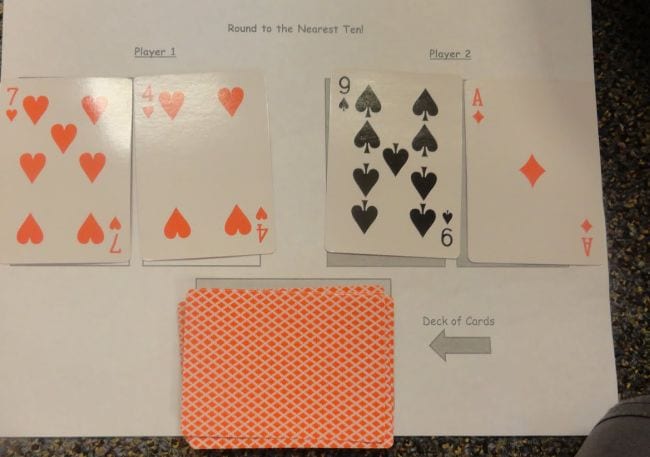 Four playing cards laid out in pairs, with a pile of face-down cards