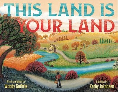 Book cover of This Land Is Your Land with illustration of boy standing on path and looking at trees, river, and rolling hills