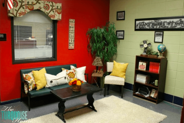 principal's office with red wall, colorful window valance and cozy seating area