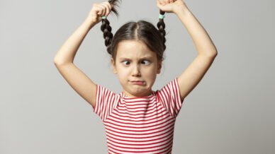 Girl holding pigtails in the air - we cant' blame the kids