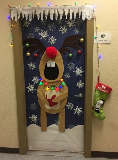 A door is made to look like Rudolph holding a caroling book while singing.