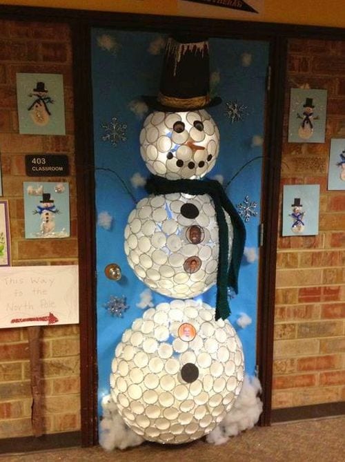 A snowman is made up of white paper cups and lit up. It is used as a door decoration.