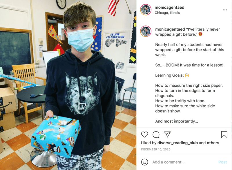 Student with mask on holds up a wrapped gift in blue patterned paper