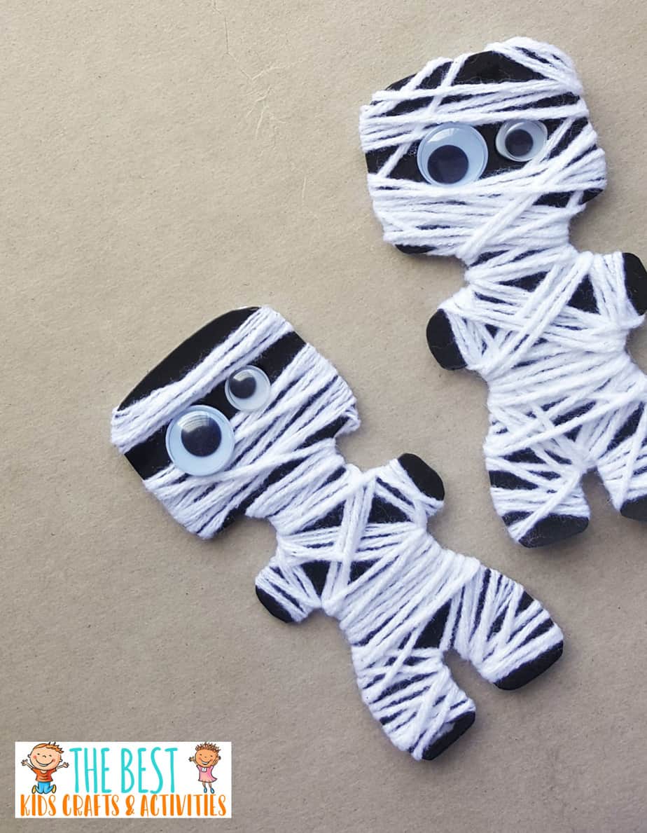 Little black cutouts of people are wrapped in white strings with googley eyes (Halloween Activities)