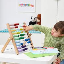 A little girl plays with an abacus.