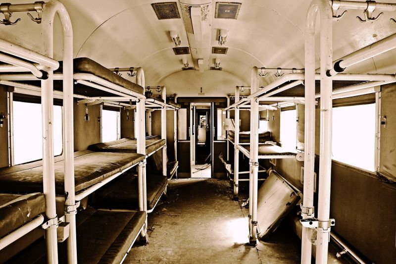 Sepia-toned image of an old sleeper train car in disrepair