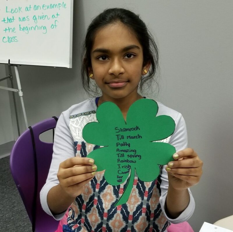 student holding an acrostic poem for a st patrick's day activity