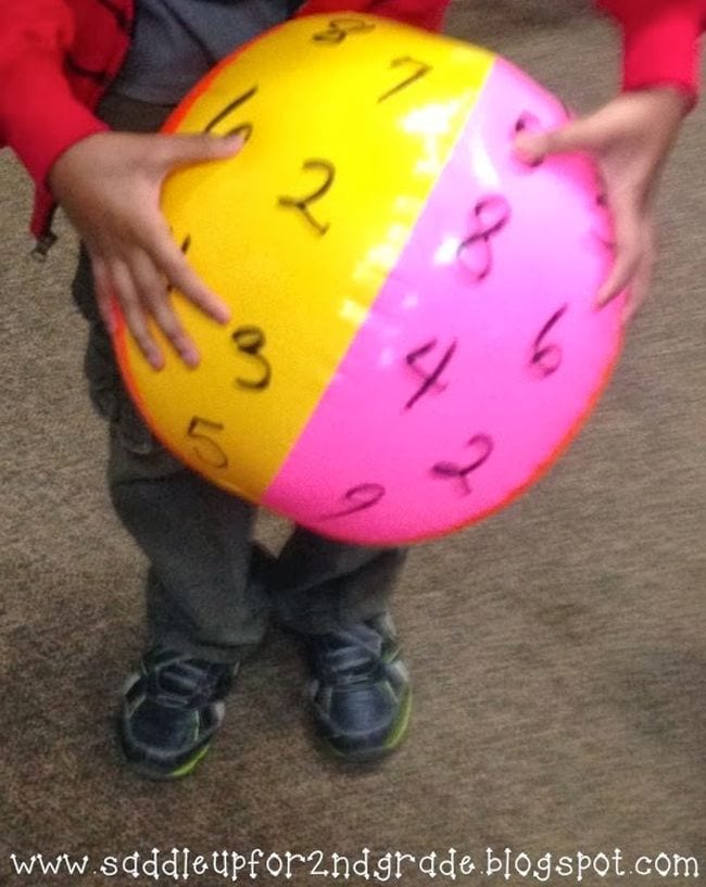 Student holding a beach ball marked with numbers (Active Math Games)