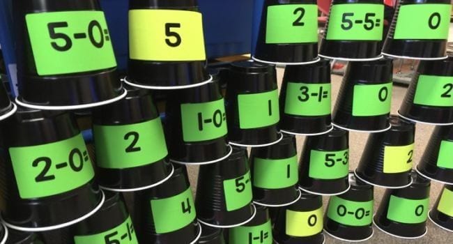 Plastic cups with math problems and numbers, stacked into a pyramid (Math Facts Practice)