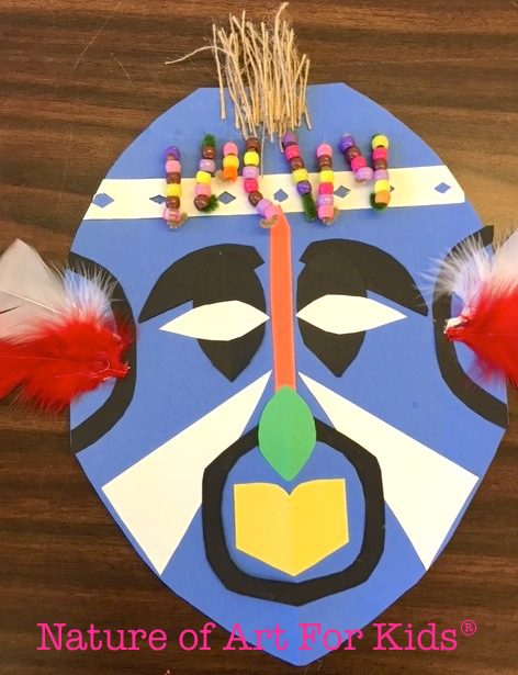 An African mask is constructed from paper, beads, and other mixed media. 