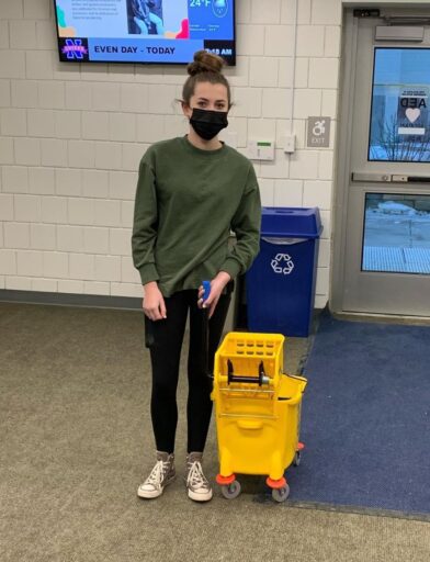 Student using a mop bucket as a backpack